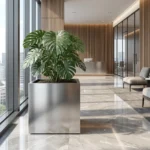 Metalowa donica kwadratowa ze stali szczotkowanej z dużą rośliną w nowoczesnym wnętrzu