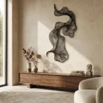 Metalowa dekoracja ścienna Abstrakcyjna Fala w nowoczesnym salonie na jasnej ścianie