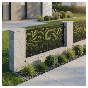 Metalowy panel ogrodzeniowy w ciemnym kolorze z dekoracyjnym roślinnym wzorem zamontowany między jasnymi słupkami przy nowoczesnej posesji.