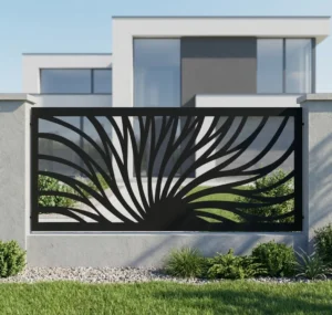 Metalowy panel ogrodzeniowy w czarnym kolorze z dynamicznym ażurowym wzorem promieni zamontowany między jasnymi słupkami przy nowoczesnym domu.