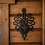 Metalowy wieszak ścienny Parzenica Królewska zamontowany na drewnianej ścianie w stylu góralskim.