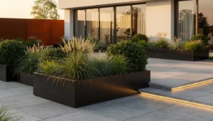 Czarne donice metalowe w nowoczesnym ogrodzie z betonem i cortenem