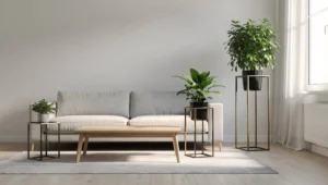 Trzy metalowe kwietniki o różnych wysokościach ustawione obok sofy, stolika kawowego i okna w nowoczesnym salonie.