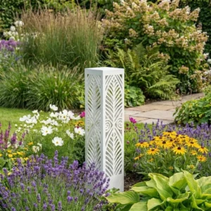 Kolumna ogrodowa metalowa Harmonia Liści z ażurowym wzorem liści ustawiona w ogrodzie wśród kwiatów i roślin