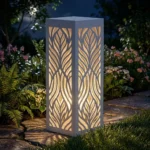 Metalowy lampion ogrodowy Cień Natury z organicznym ażurowym wzorem w nocnej aranżacji ogrodu