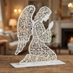 Anioł Modlitwy Klęczący – metalowa dekoracja wolnostojąca ustawiona na drewnianym stole w eleganckim wnętrzu