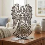 Anioł Serca – metalowa dekoracja wolnostojąca ustawiona na drewnianej komodzie w jasnym wnętrzu