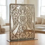 Anioł Serca Ornament – metalowa dekoracja wolnostojąca ustawiona na drewnianym stole w jasnym wnętrzu