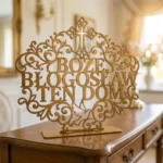 Boże Błogosław Ten Dom – metalowa dekoracja wolnostojąca ustawiona na drewnianej komodzie w eleganckim wnętrzu