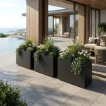 Czarna metalowa donica prostokątna do ogrodu z trawami ozdobnymi i krzewami przy nowoczesnym domu