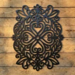 Dekor ścienny metalowy kaszubski z motywem serca i ornamentów na drewnianej ścianie