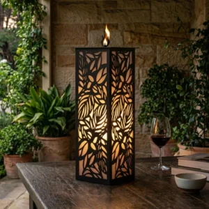 Lampion Roślinna Wieża – czarny metalowy lampion z ażurowym roślinnym wzorem ustawiony na drewnianym stole