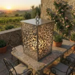 Lampion Roślinny Płomień – metalowy lampion z ażurowym roślinnym wzorem ustawiony na kamiennym stole na tarasie