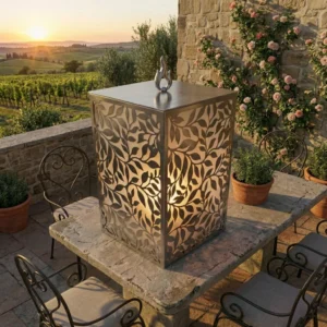 Lampion Roślinny Płomień – metalowy lampion z ażurowym roślinnym wzorem ustawiony na kamiennym stole na tarasie