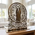 Matka Boża Liliowa – metalowa dekoracja wolnostojąca ustawiona na drewnianej komodzie w jasnym wnętrzu