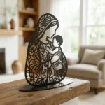 Matka Czułości – metalowa dekoracja wolnostojąca ustawiona na drewnianej półce w jasnym wnętrzu