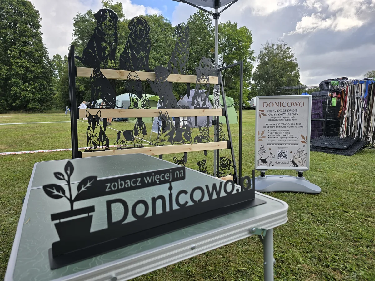 Stoisko Donicowo na wystawie psów – metalowe sylwetki ras psów i tabliczka zobacz więcej na Donicowo.pl
